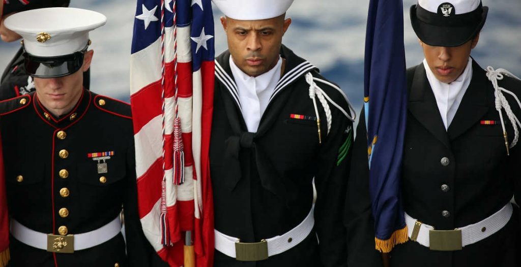 U.S. Sailors and a Marine with a color guard stand in formation during a burial at sea March 19, 2013, aboard the amphibious assault ship USS Kearsarge (LHD 3) in the Atlantic Ocean. The ship deployed as part of the Kearsarge Amphibious Ready Group with embarked Marines assigned to the 26th Marine Expeditionary Unit to support maritime security operations and theater security cooperation efforts in the U.S. 5th Fleet and U.S. 6th Fleet areas of responsibility. (DoD photo by Chief Mass Communication Specialist Tommy Lamkin, U.S. Navy/Released)